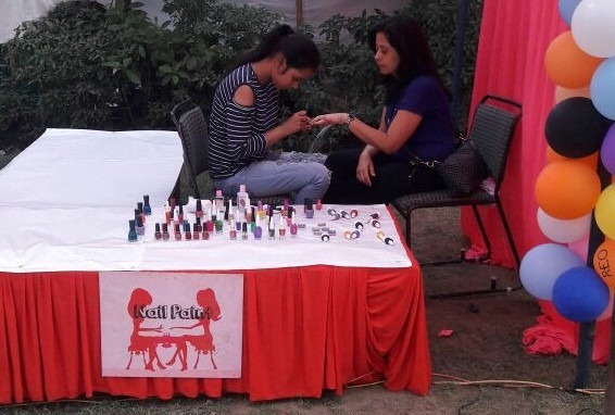 Nail art artist creating a design on a child's hand at a birthday party in Agra